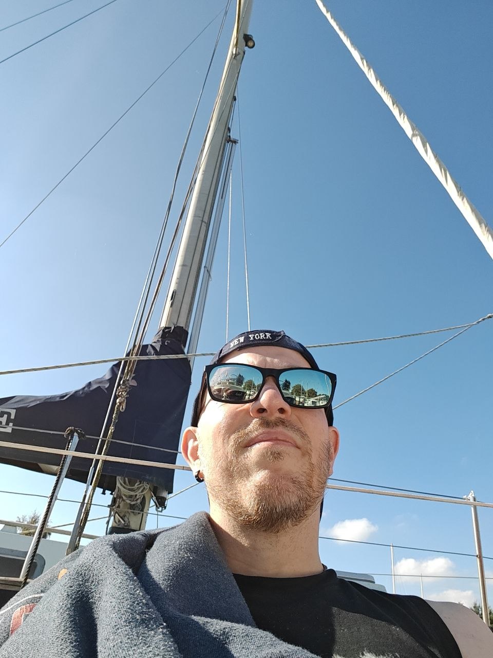 selfie on a sailboat deck below the mast